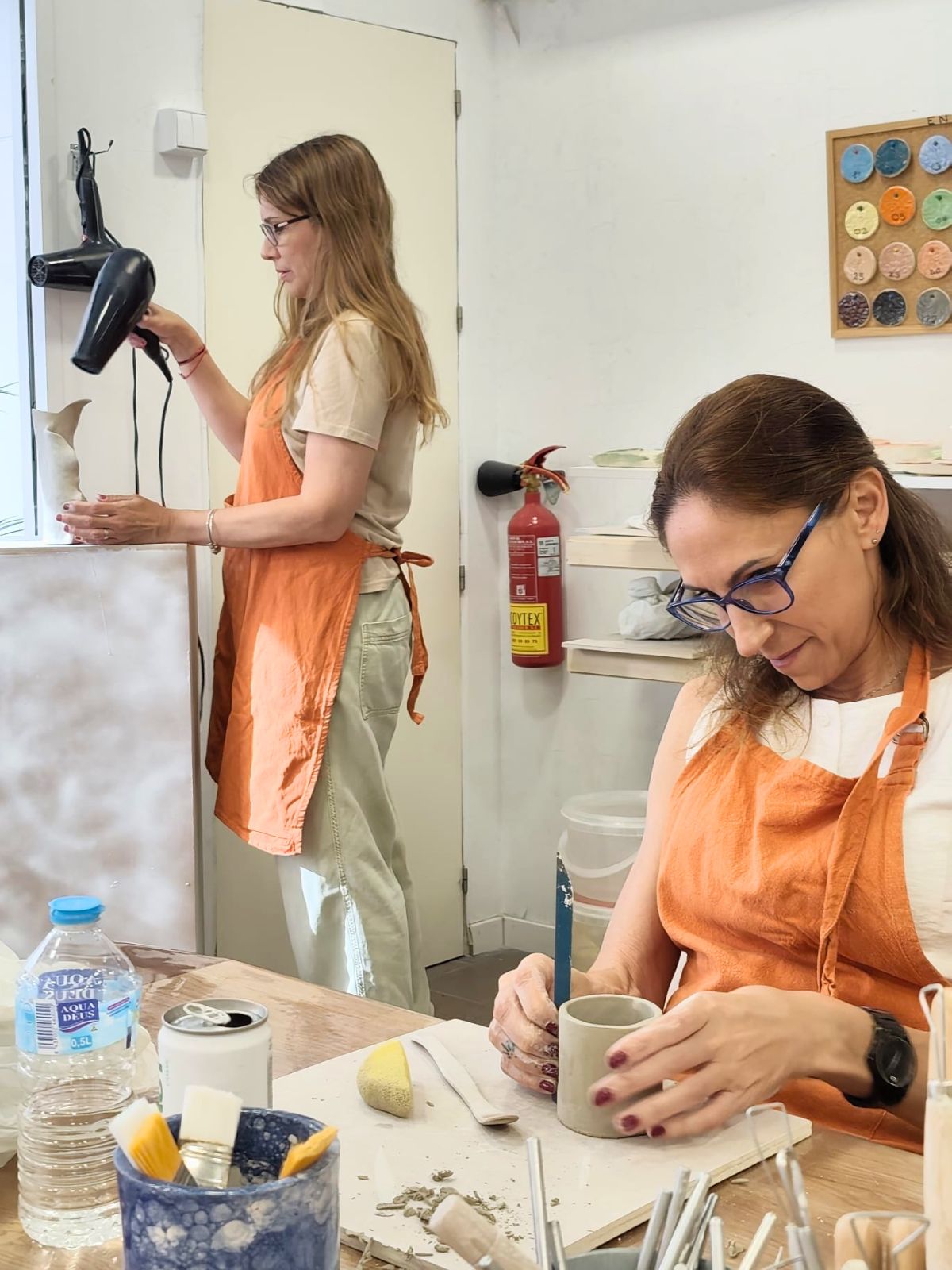Alumnas modelando y secando piezas en una clase de cerámica en Málaga